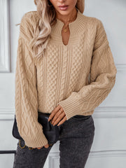 Camel cable knit sweater with keyhole neck and ribbed cuffs.
