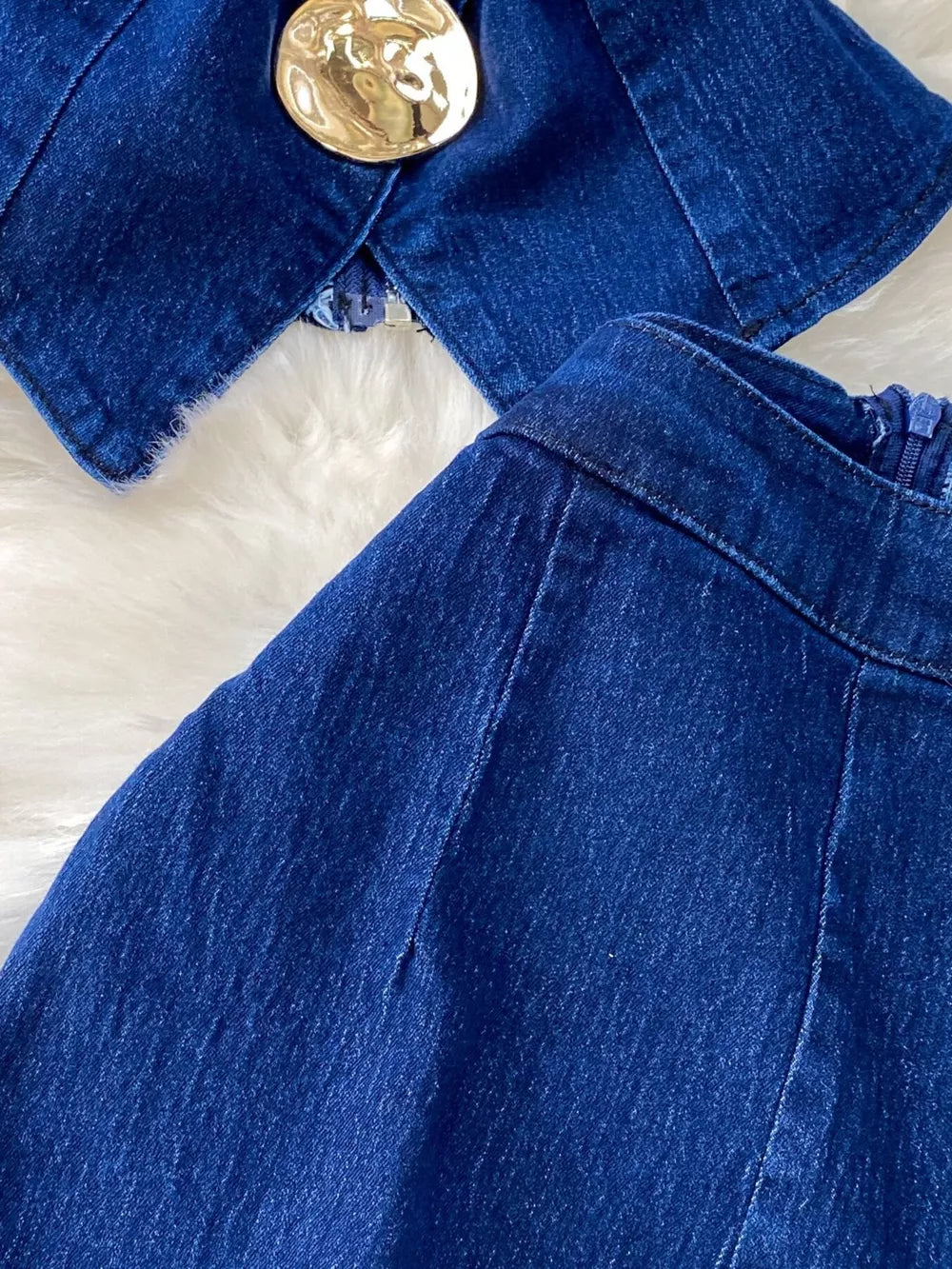 Dark blue denim vest with asymmetrical button detail and flare jeans.