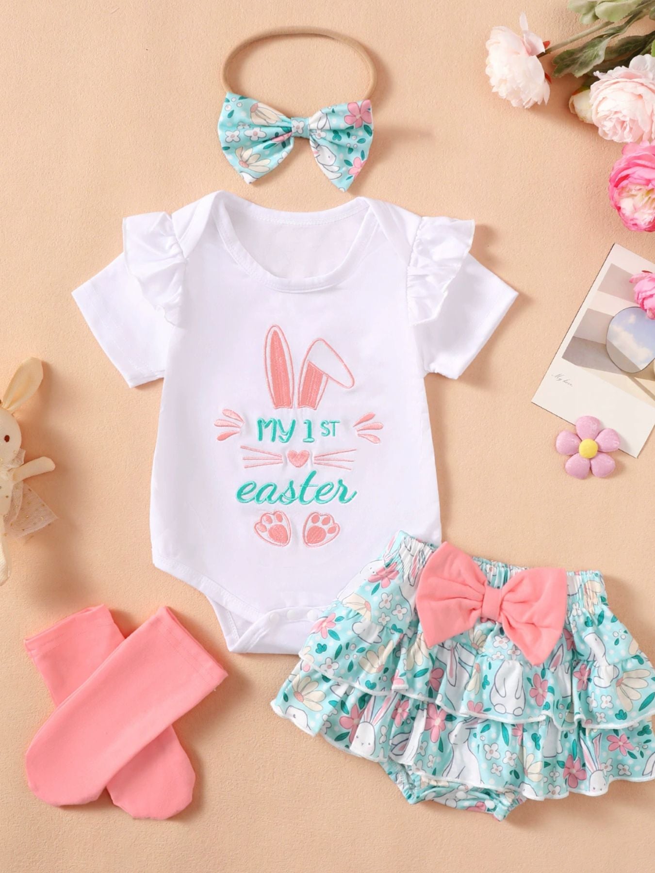 White ruffled bodysuit with Easter bunny graphic and floral ruffled skirt with pink bow.