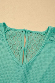 Teal waffle knit V-neck shirt with lace back detail and button closure.