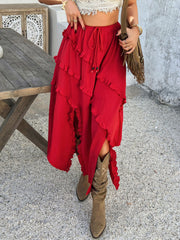 Scarlet midi skirt with cascading ruffles and a slit, styled with boots.