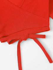 Red wrap crop blouse with tie detail and textured fabric