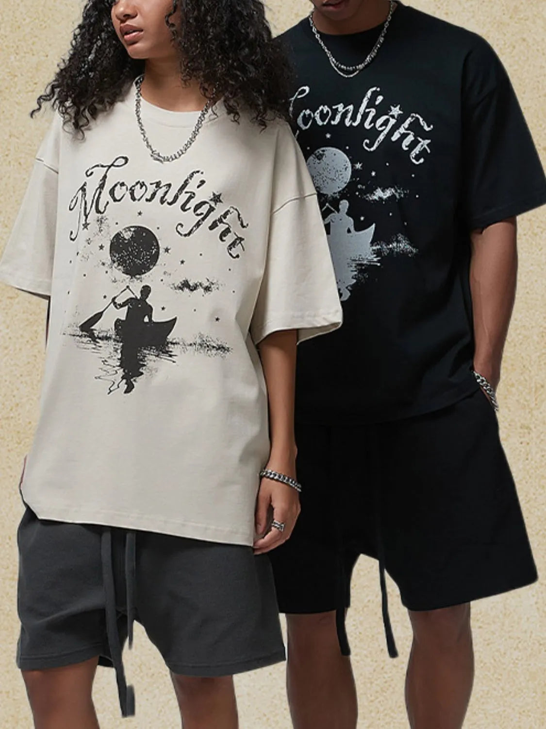 Ivory oversized graphic tee with moonlight canoe print and black oversized graphic tee with moonlight print