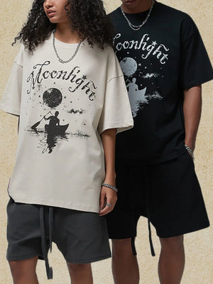 Ivory oversized graphic tee with moonlight canoe print and black oversized graphic tee with moonlight print