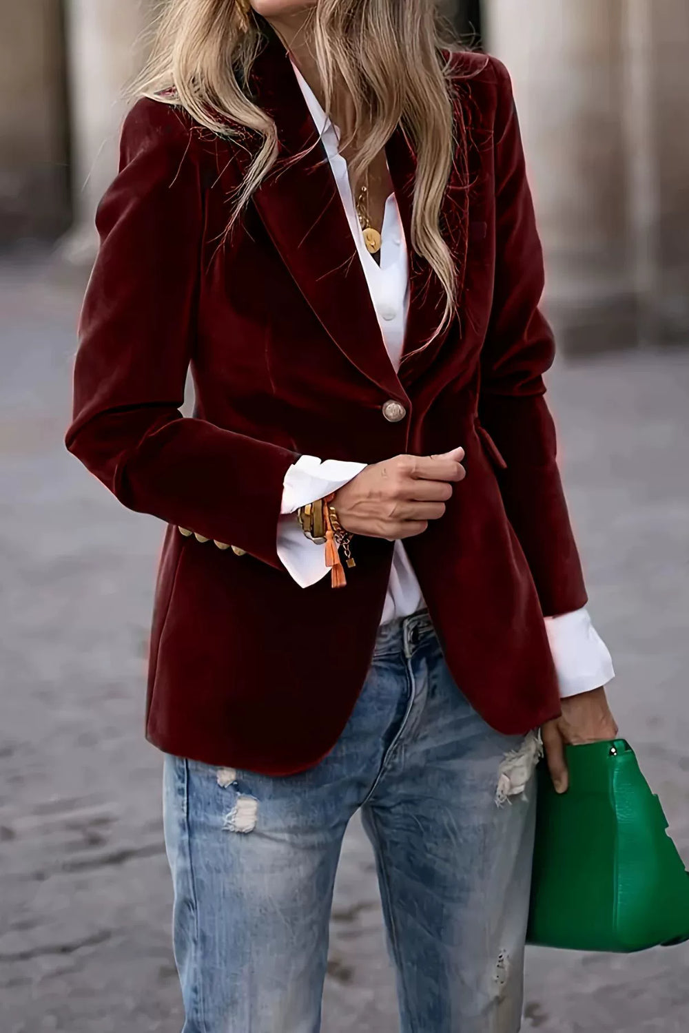 Burgundy velvet blazer with sculpted shoulders, single button closure, and gold button details on cuffs.
