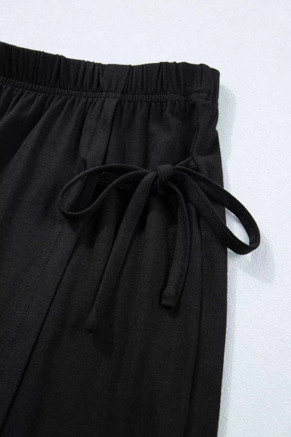 Black tie-wrap two-piece ensemble with drawstring detail