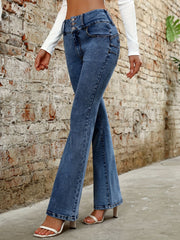 Medium wash denim bootcut jeans with a high rise and button fly, styled with white heels.