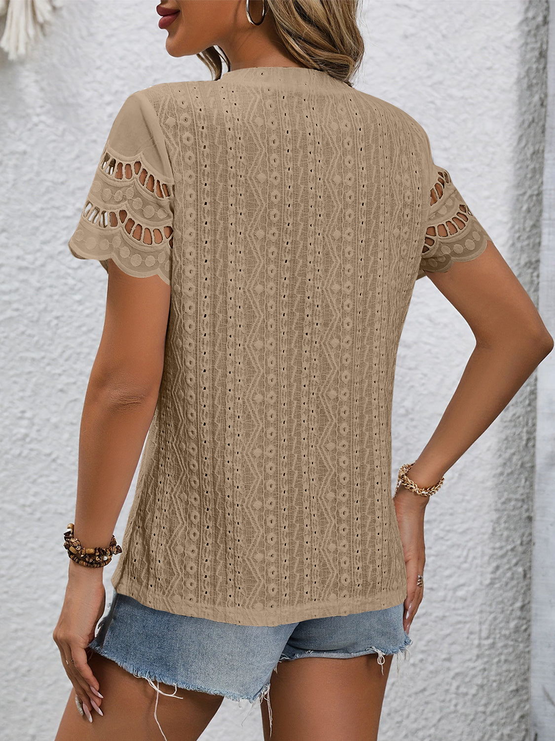 Camel eyelet blouse with scalloped short sleeves and intricate patterned fabric.