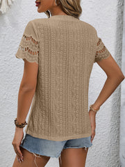 Camel eyelet blouse with scalloped short sleeves and intricate patterned fabric.