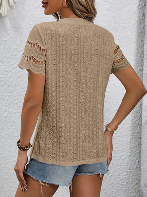 Camel eyelet blouse with scalloped short sleeves and intricate patterned fabric.