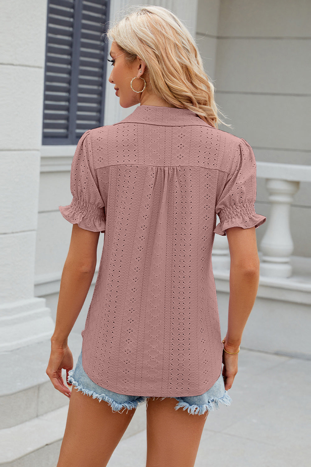 Blush pink eyelet polo blouse with short ruffled sleeves and a collared neckline.