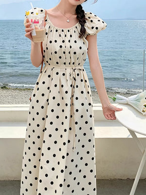 Cream polka dot midi dress with puff sleeves, drawstring waist, and scoop neckline.
