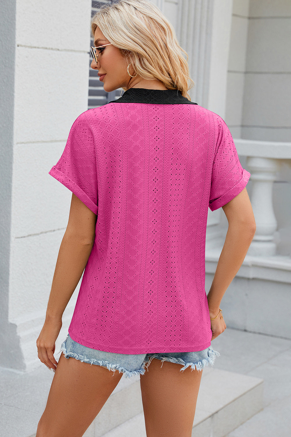 Hot Pink perforated panel polo top with black collar and cuffed short sleeves.