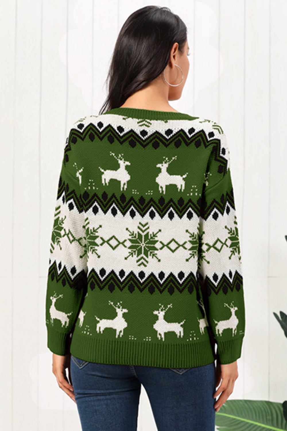 Green acrylic sweater with reindeer and snowflake Fair Isle pattern, crew neck, long sleeves.
