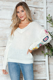 White v-neck sweater with colorful granny square crochet sleeve details