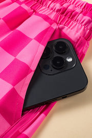 Hot pink checkerboard lounge shorts with elastic waistband and pocket detail.