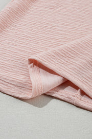 Blush pink textured blouse with ruffle sleeve detail.