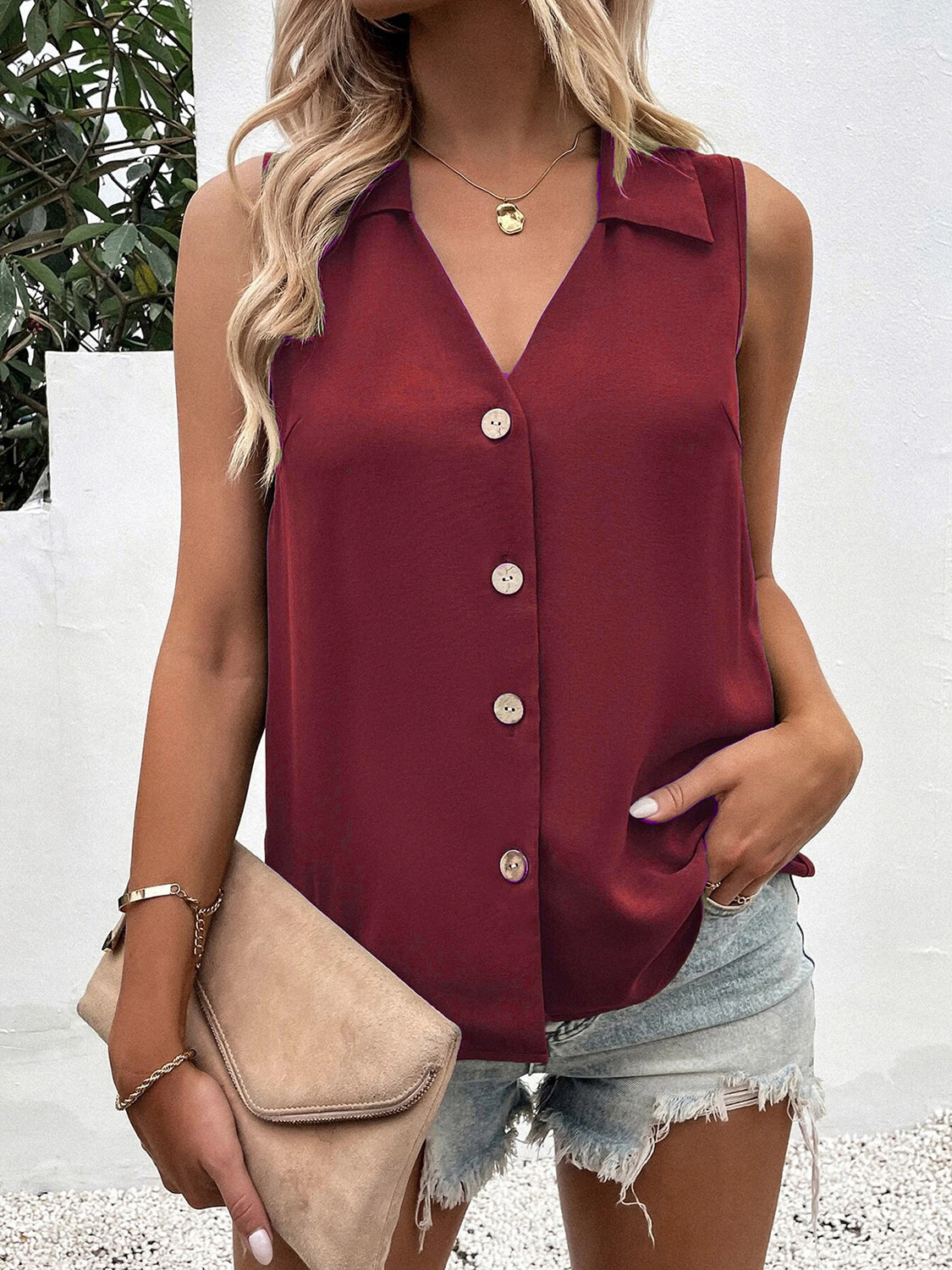 Burgundy sleeveless collared button-down blouse with a V-neck.