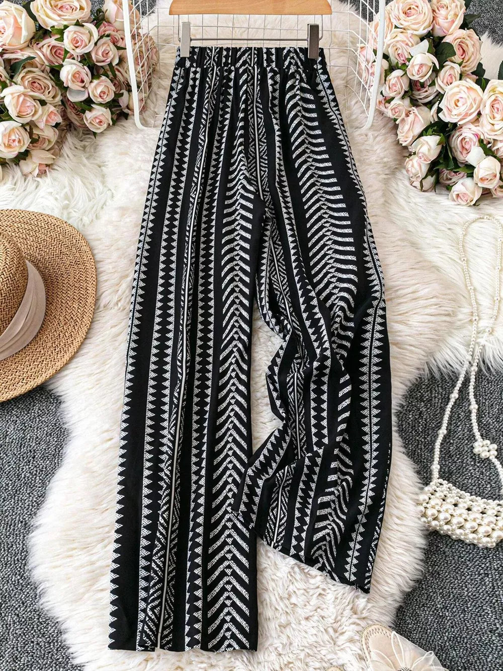 Black geometric print wide-leg maternity pants with adjustable waist and bow detail.