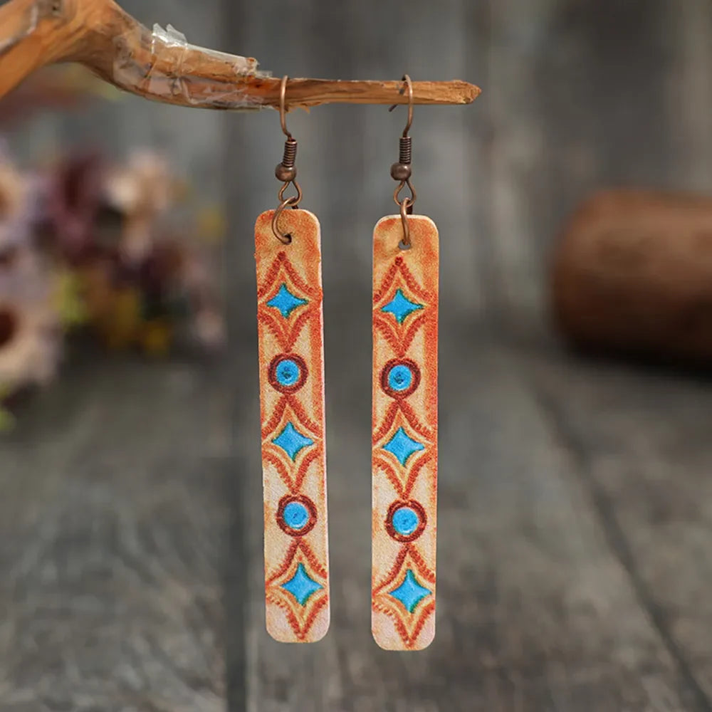 Embroidered leather dangle earrings in tangerine with blue diamond and circle pattern