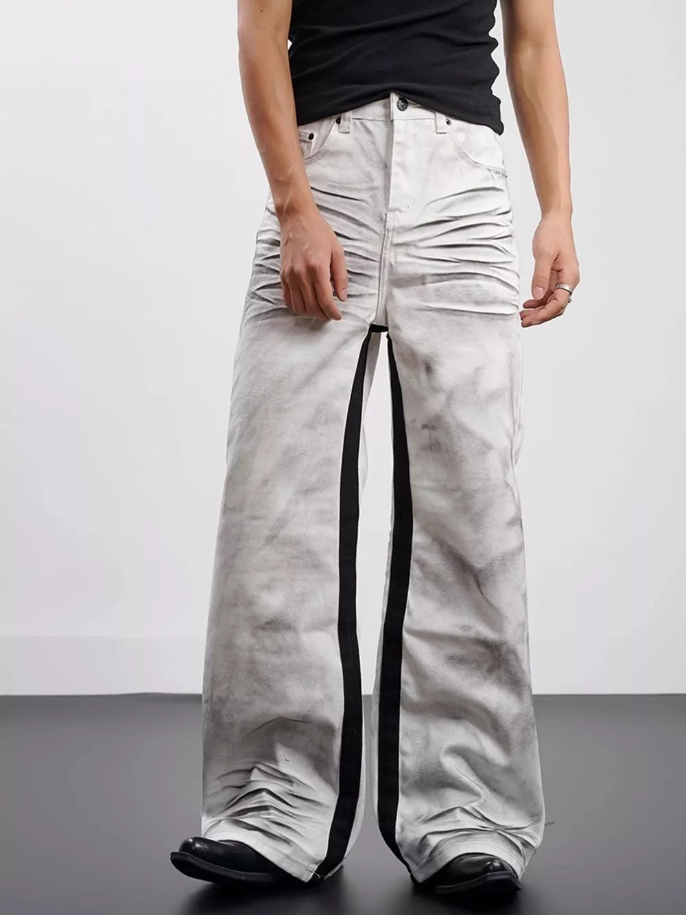 Men's wide-leg jeans in grey with black contrast stripes and ruched detailing.