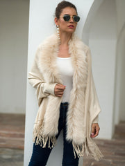 Ivory faux fur trimmed fringe cape with a draped silhouette.
