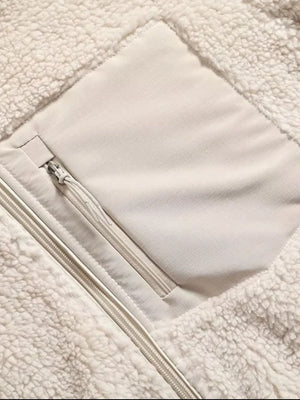 Beige sherpa zip-up jacket with a chest patch pocket and zipper details.