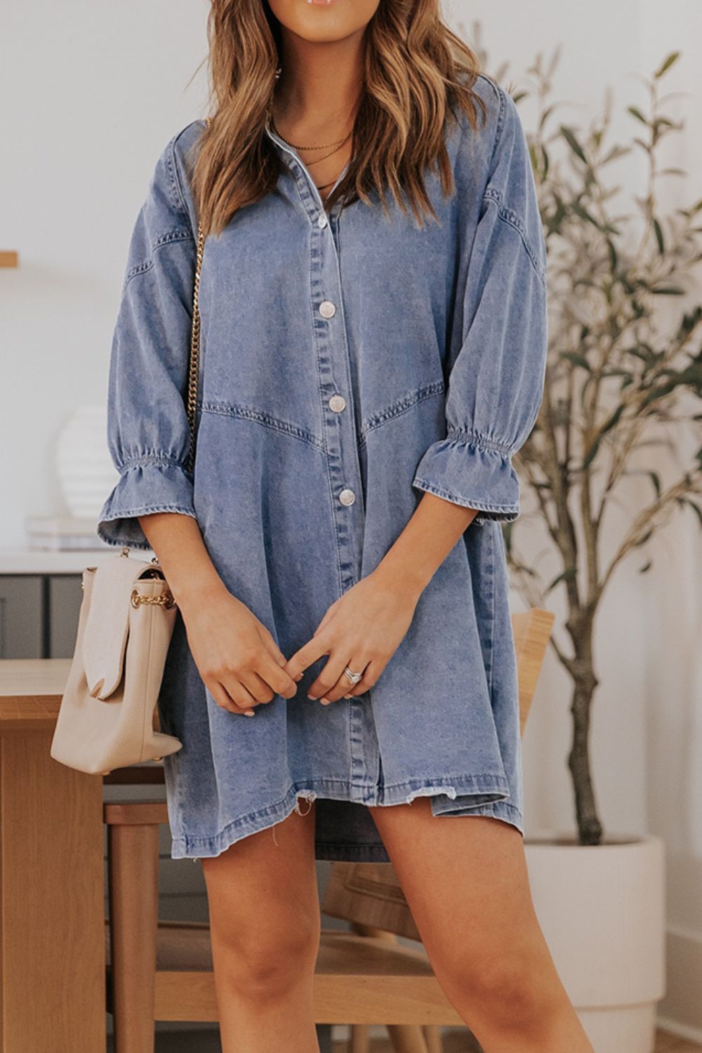 Light blue denim shirtdress with ruffled cuff detail and button front, A-line cut.