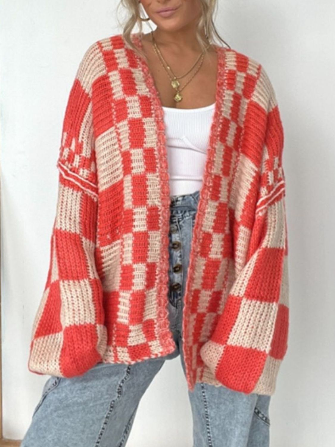 Oversized checkerboard knit cardigan in deep red and beige with balloon sleeves.