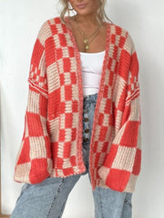 Oversized checkerboard knit cardigan in deep red and beige with balloon sleeves.