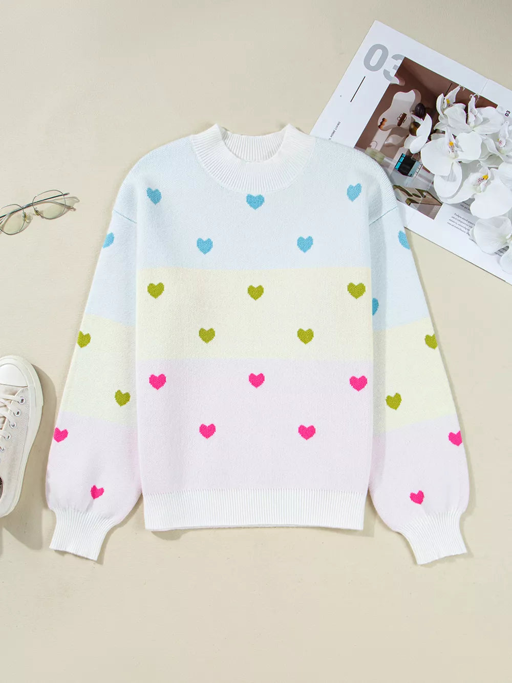 Playful heart pattern knit sweater with crew neck and colorblock design.