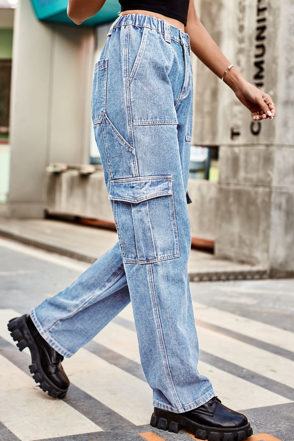Light wash denim cargo pants with relaxed fit and multiple pockets.