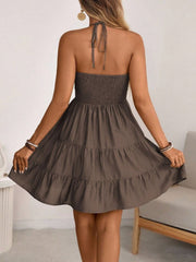 Brown ruched halter tiered mini dress with ruffles and a tie back.