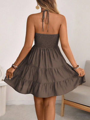 Brown ruched halter tiered mini dress with ruffles and a tie back.