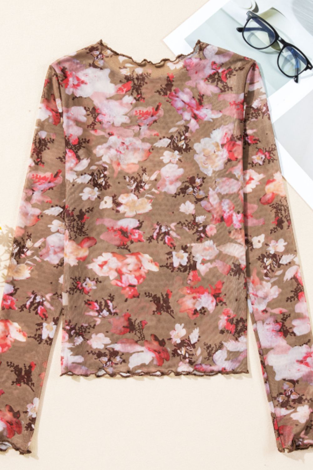 Sheer floral mock neck long sleeve top with lettuce trim.