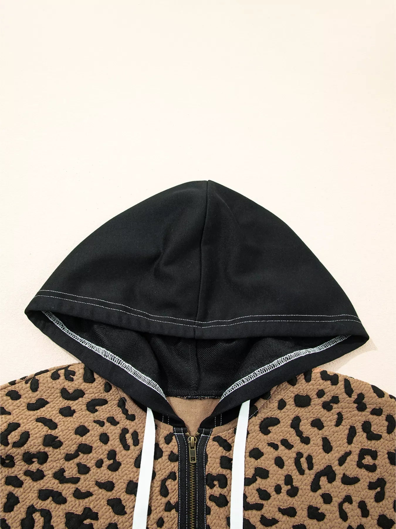 Zip front hoodie with leopard print and black hood, featuring white drawstrings.