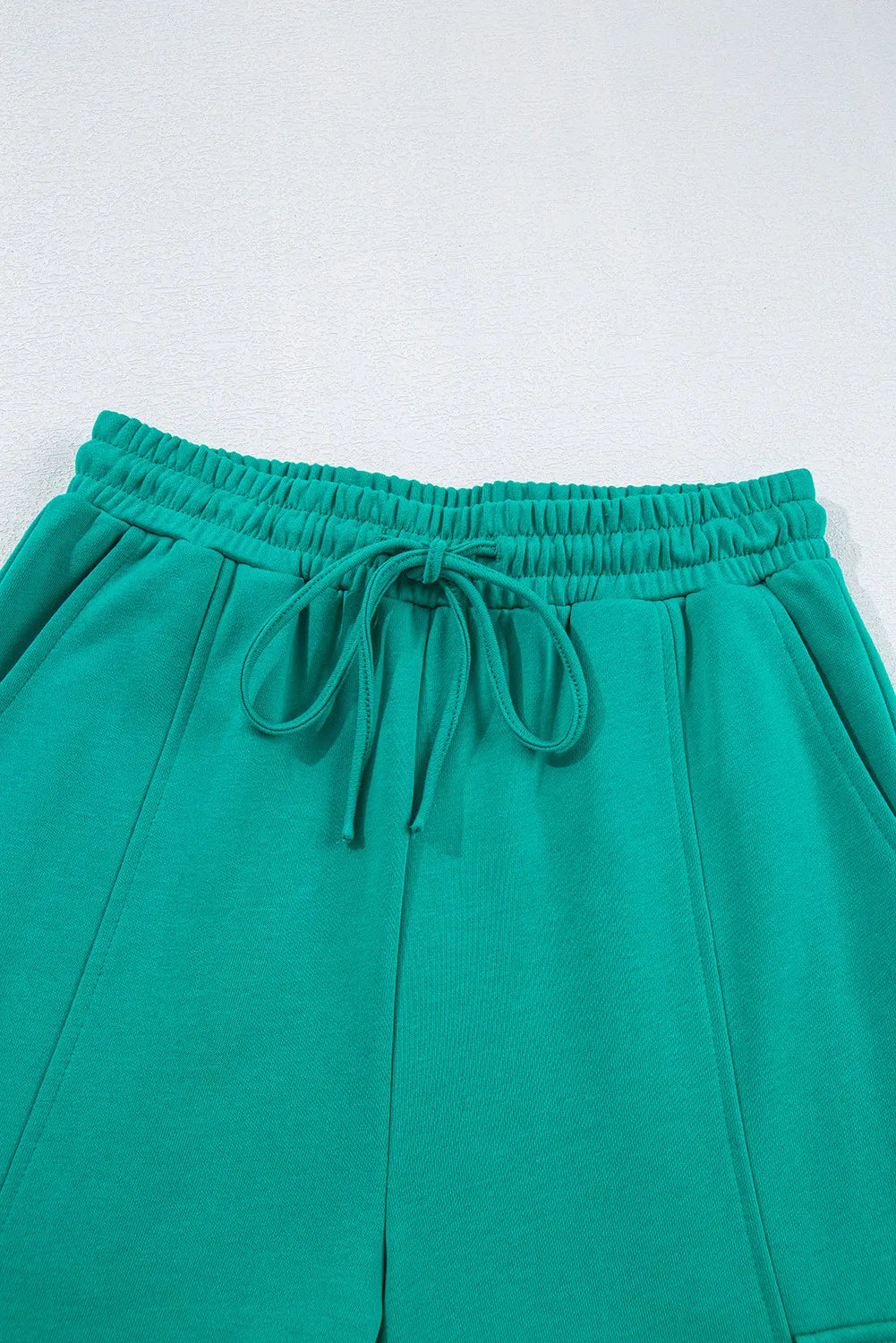 Turquoise lounge pants with elastic waistband, drawstring, and cargo pockets.