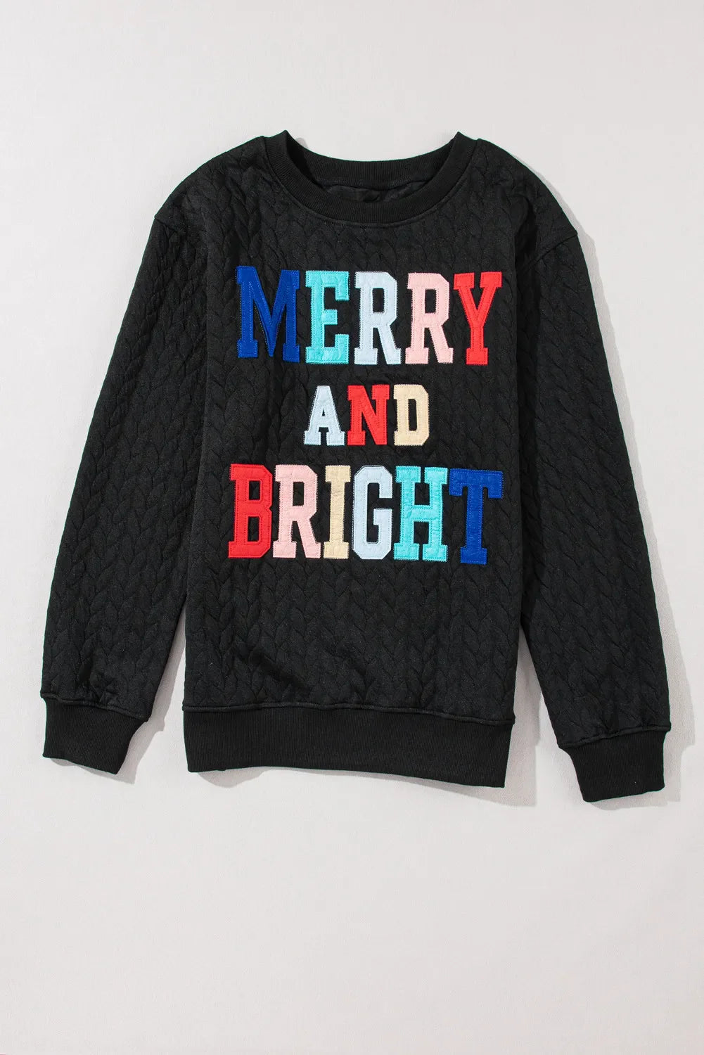 Black textured sweatshirt with "Merry and Bright" embroidered in colorful letters