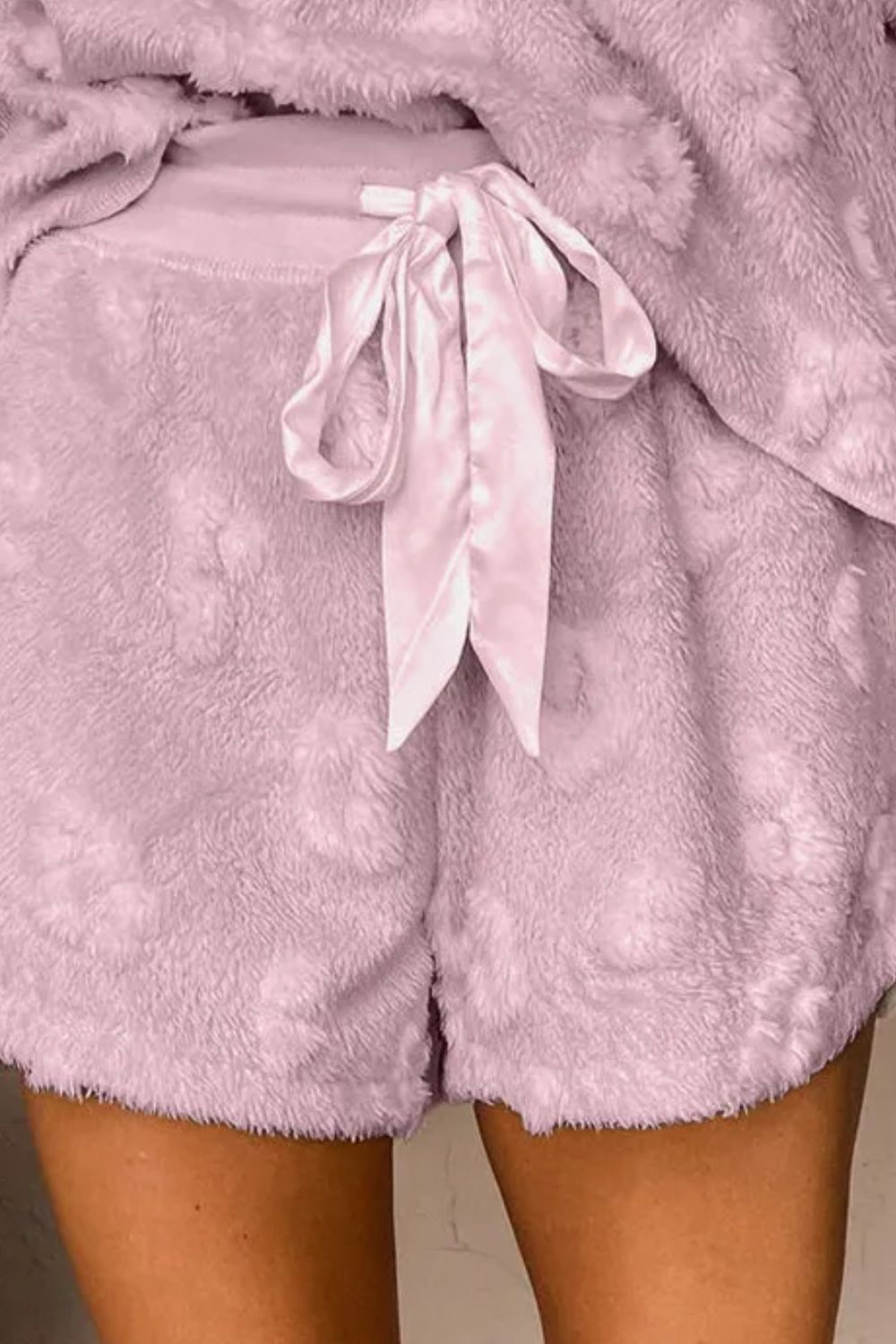 Textured blush pink lounge shorts with adjustable satin tie and fuzzy heart pattern.