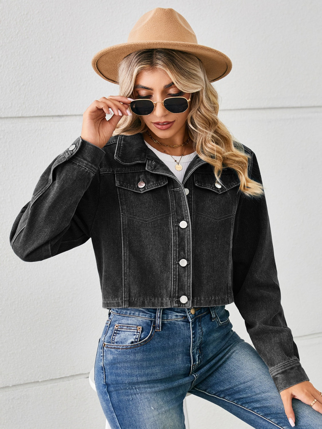 Black cropped denim trucker jacket with button front and chest pockets.