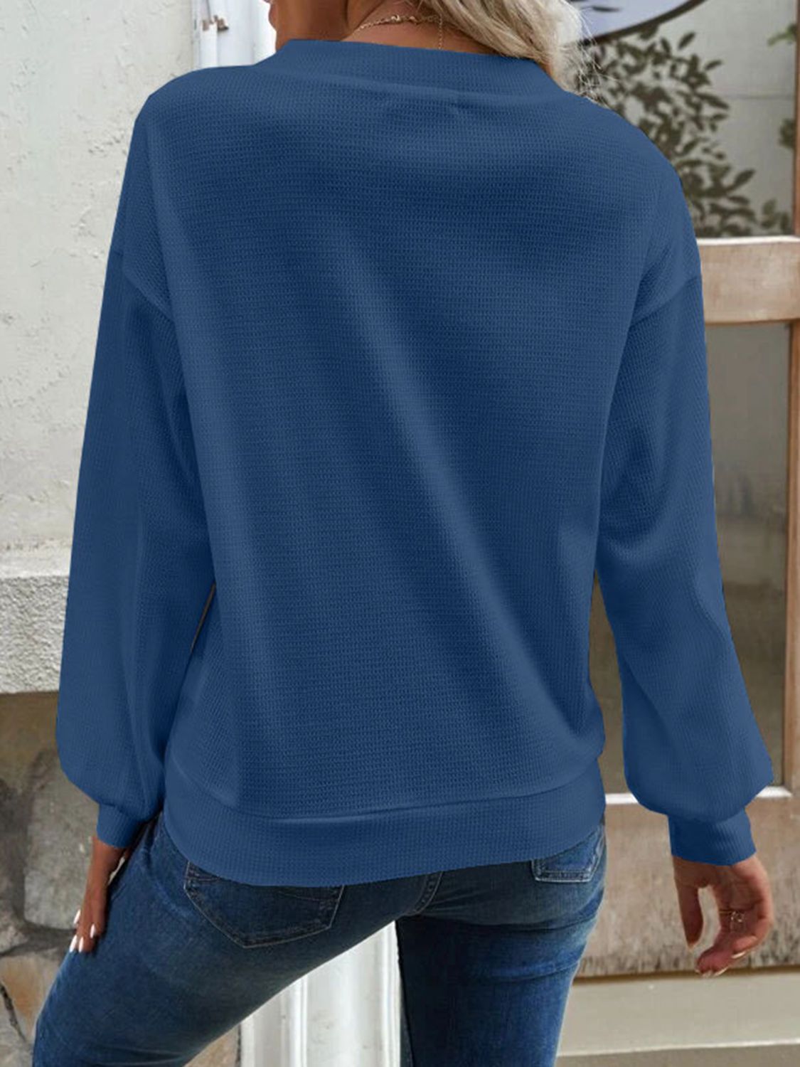 Blue waffle knit button-down cardigan with long sleeves and a crew neckline.