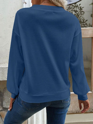 Blue waffle knit button-down cardigan with long sleeves and a crew neckline.
