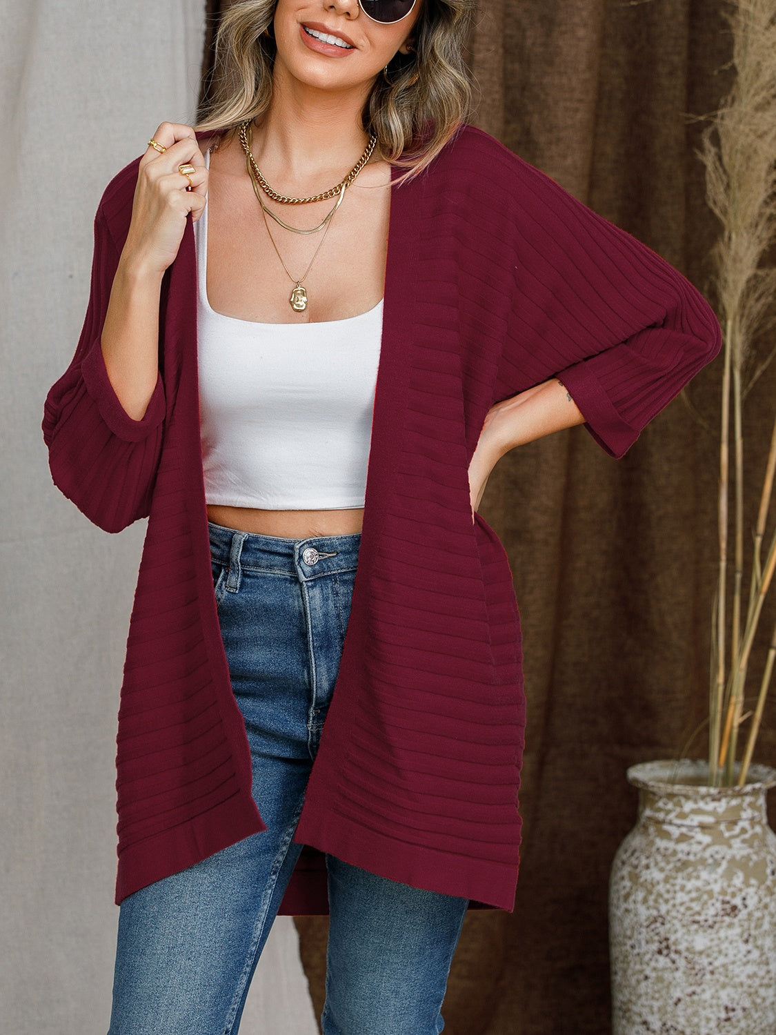 Burgundy ribbed sleeve cardigan with open front and textured knit.