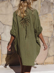 Green cotton blend button-down shirt dress with embroidered palm tree detail on back.