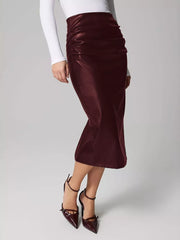 Burgundy faux leather midi skirt with ruched detail and body-con fit.