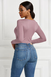 Dusty Pink long sleeve bodysuit with a plunge neckline and zip front, styled with blue jeans.