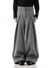 Men's grey oversized pleated wide-leg trousers with button fly and decorative chain detail.