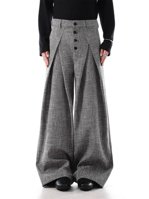 Men's grey oversized pleated wide-leg trousers with button fly and decorative chain detail.