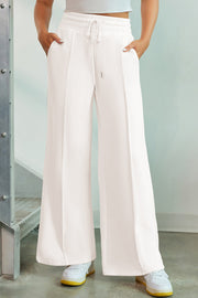 White palazzo joggers with center seam detail and drawstring waist.