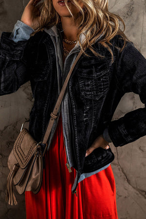 Black denim jacket with grey hooded layer, zip front, chest pockets, and distressed details.
